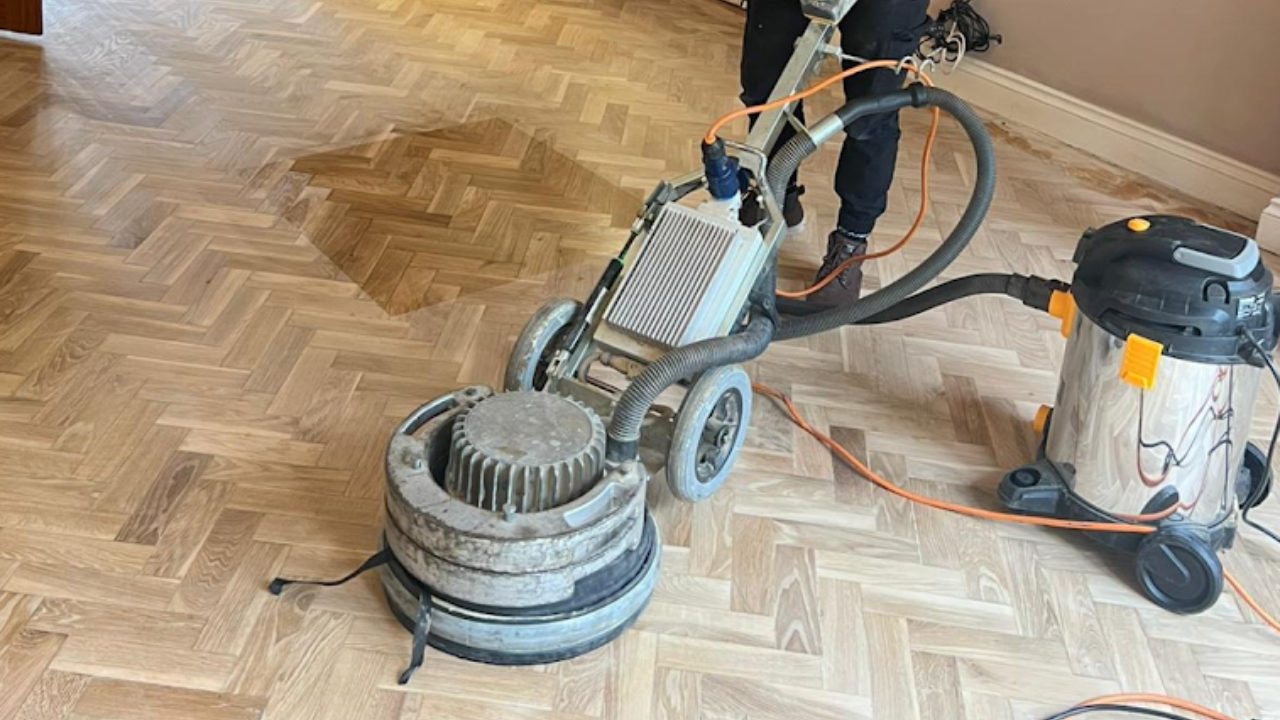 Sanding Parquet Floors in Sydenham – technician using a dust-free rotary sander with HEPA extraction on a herringbone oak parquet floor.