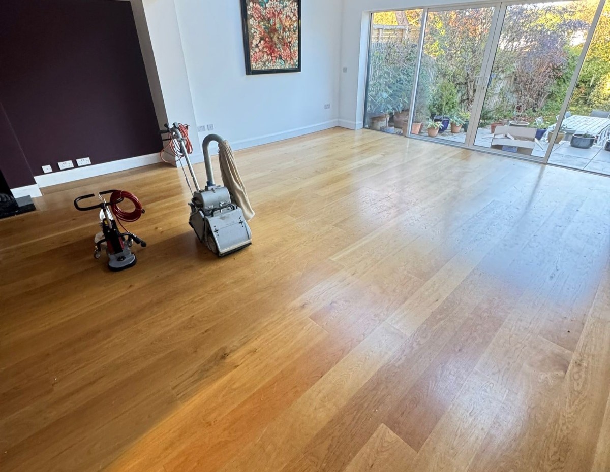 Wood Floor Sanding in Sydenham on an engineered oak wide-plank living room floor, with professional sanding and buffing machines ready to refinish the surface.