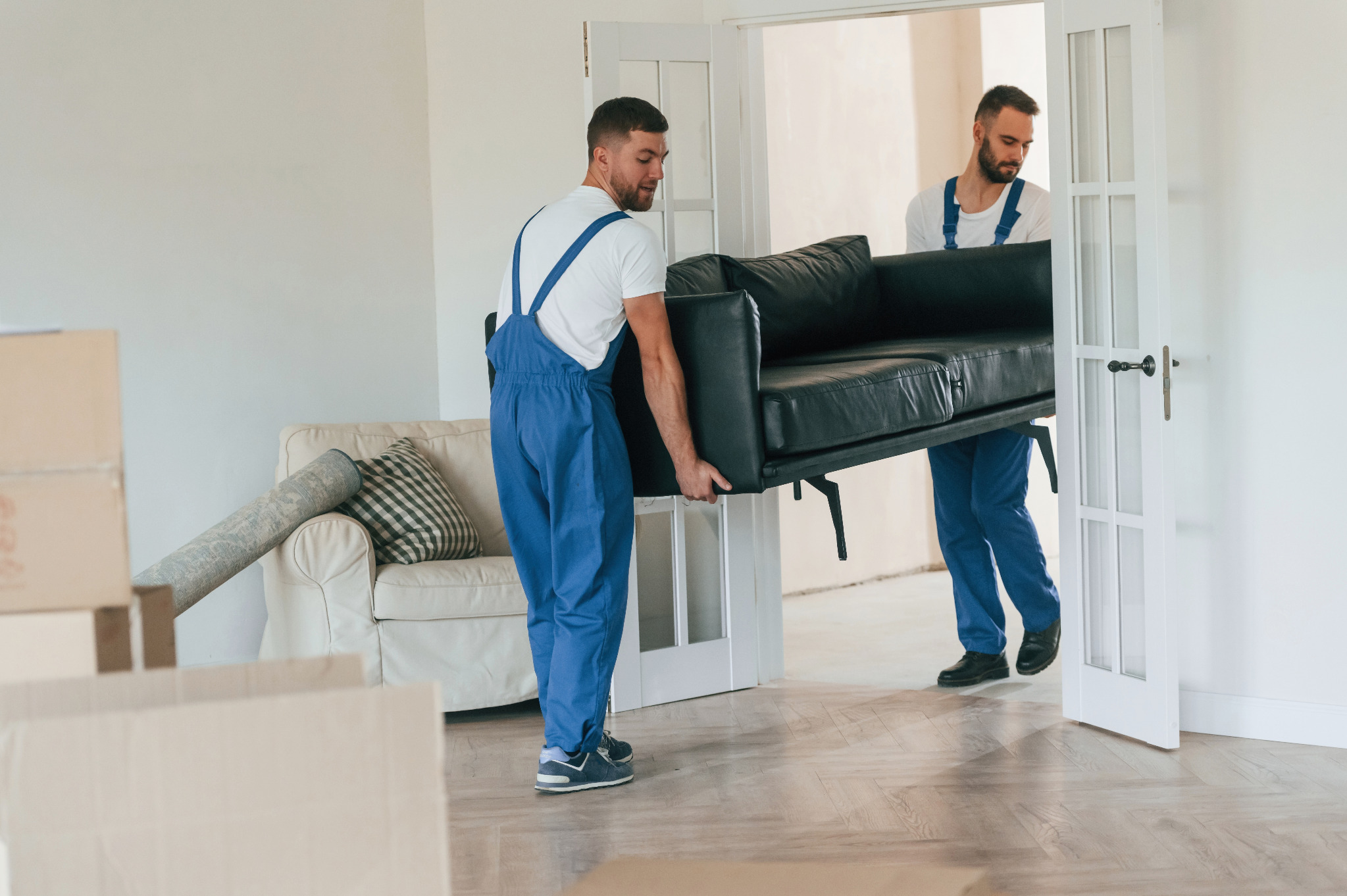 Professional team moving furniture off an oak herringbone parquet floor in a Sydenham home before Wood Floor Sanding and refinishing.