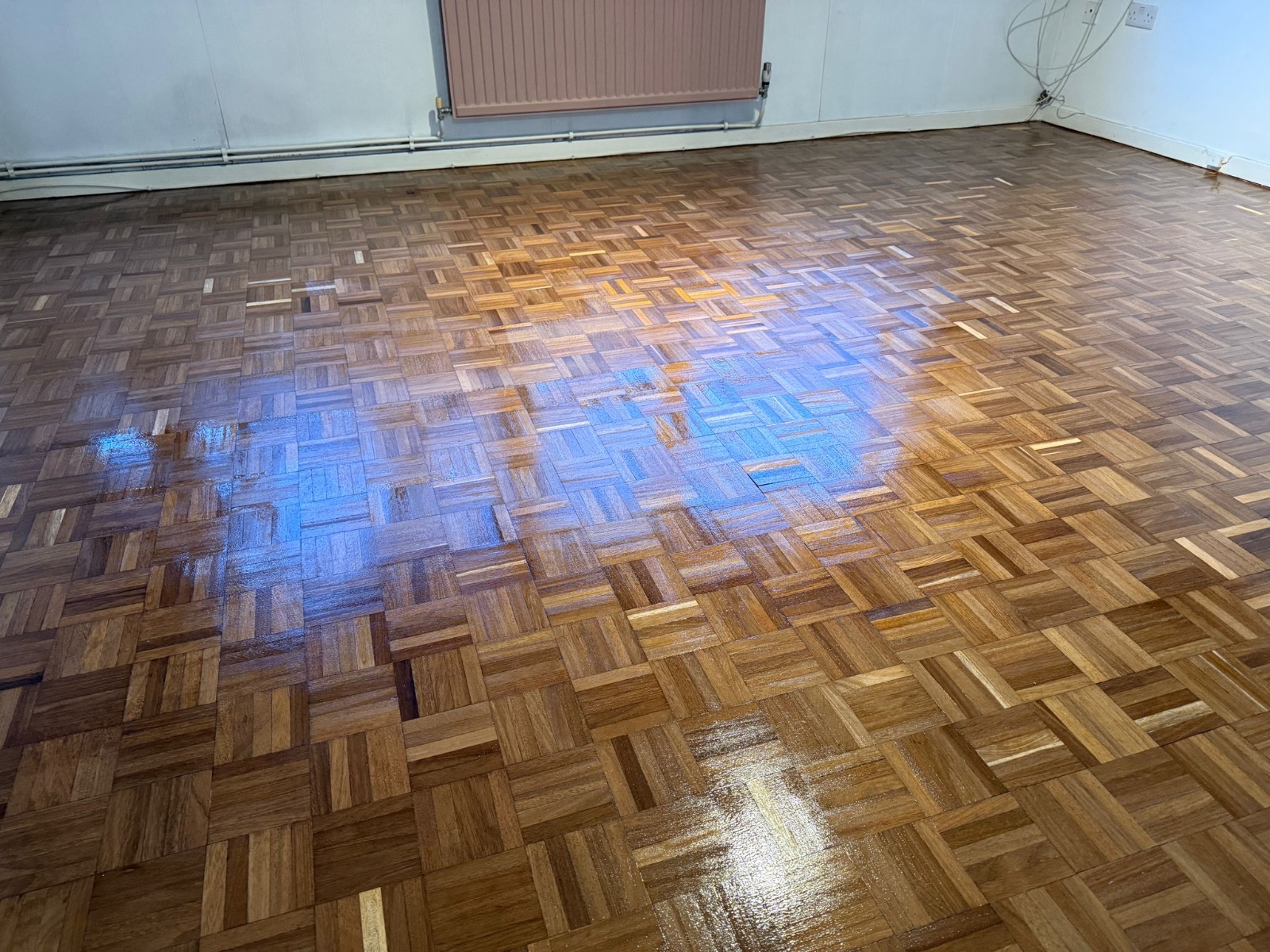Wood Floor Sanding in Sydenham on dark oak mosaic parquet flooring with a polished restored finish in a spacious room
